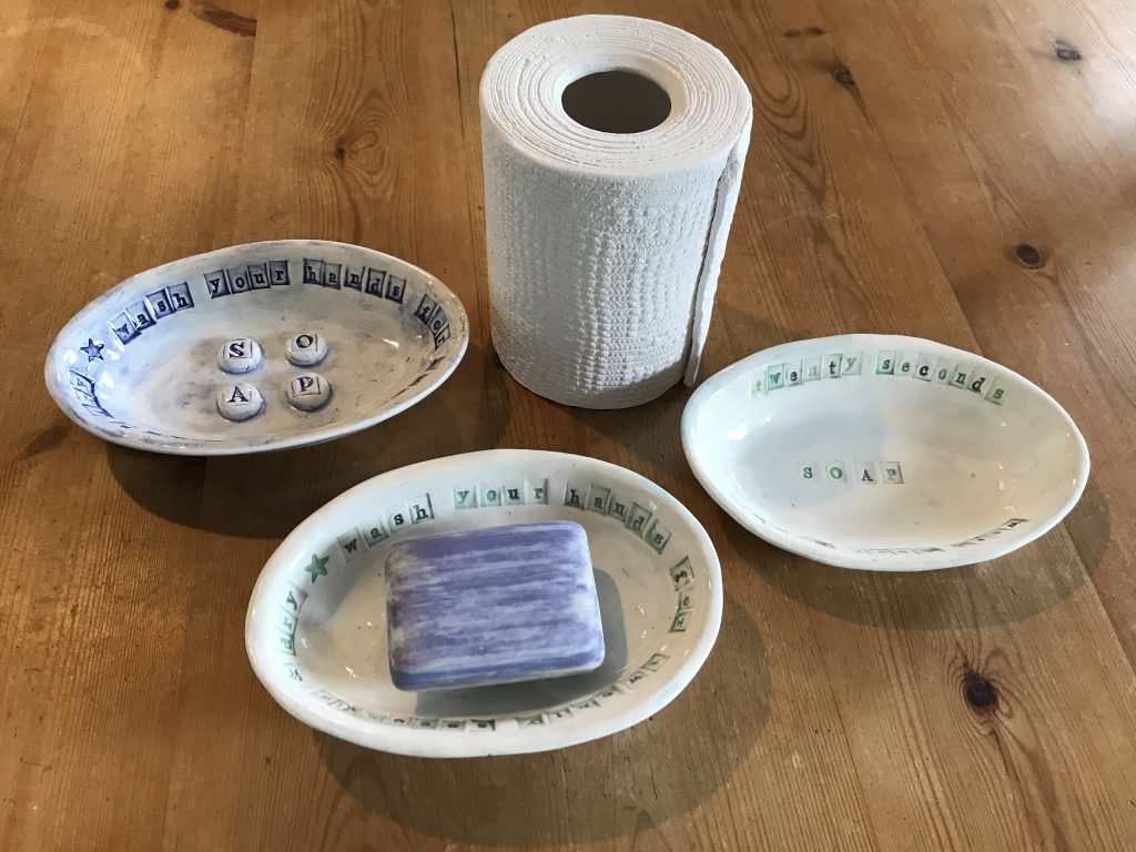 three soap dishes and a toilet roll holder.