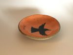 small orange dish with an image of a tui bird.